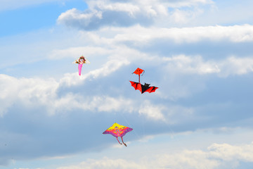 Fototapeta na wymiar multi colored kites in the blue sky background