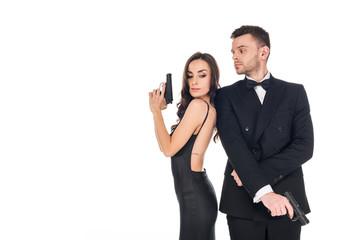 beautiful couple of secret agents in black clothes posing with guns, isolated on white