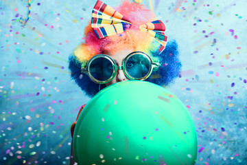 Fröhliche Frau feiert Fasching mit Perücke und Girlande 
