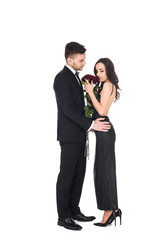 attractive elegant couple in black clothes posing with red roses on valentines day, isolated on white