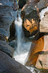 Water cascade of the river Toce among the rocks smoothed in the gorges of the ravines of Uriezzo in val Antigorio, in Piedmont, Italy.