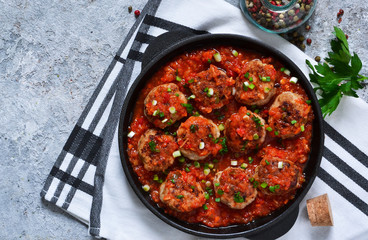 Meat balls in tomato sauce with spices concrete background. View from above.