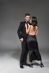 beautiful elegant couple in black clothes hugging on grey