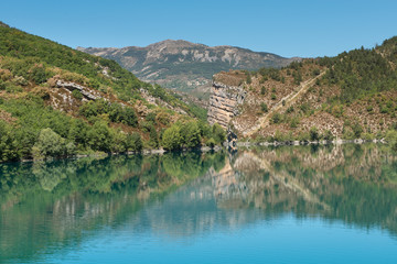 Fototapeta na wymiar Lake of Castillon, a lake with mountains and green hills with a blue sky