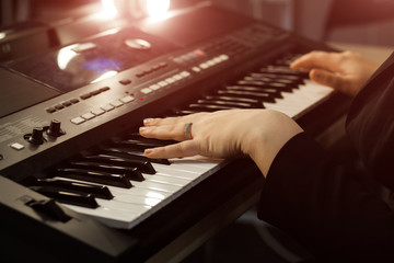 Close up of woman's hand playing the piano. Woman playing on electric piano. Female synthesizer...