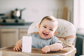 A child,  a girl drinking juice or milk with a tube of white packaging there is a place for the...