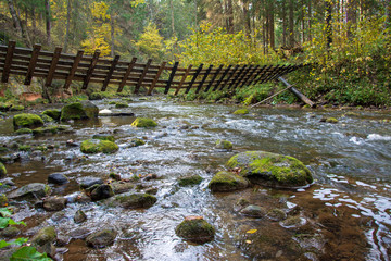 Obraz premium rocky river with twisted bridge