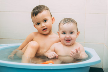 children, brother and sister in the bathroom swimming, playing splashing