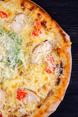 Caesar's chicken and tomatoes, grated cheese and sauce pizza