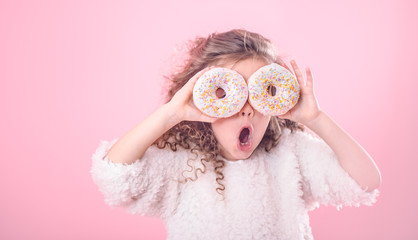 Portrait of a little surprised girl with donuts