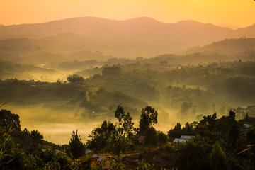 Gentle yellow light and light mist over the hills in country side with traditional houses and the...