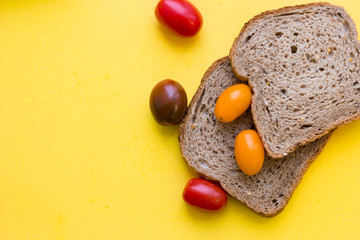 School lunch box. Bread, candies, baby corns, carrot and tomatoes in green plastic container