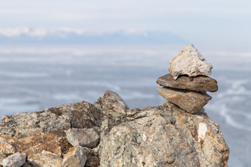 Stone pyramids for spirits on Olhon island. Baikal lake winter landscape