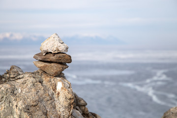 Stone pyramids for spirits on Olhon island. Baikal lake winter landscape