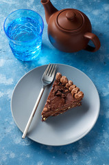 Piece of dark chocolate cake with buttercream, nuts and berry jam