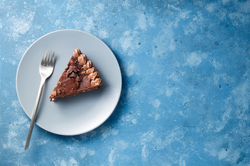 Piece of dark chocolate cake with buttercream, nuts and berry jam