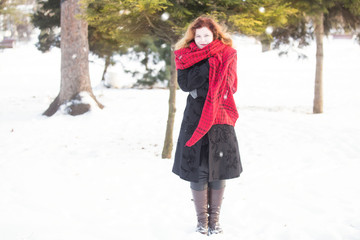 Natural redhead woman with red scarf in winter snow