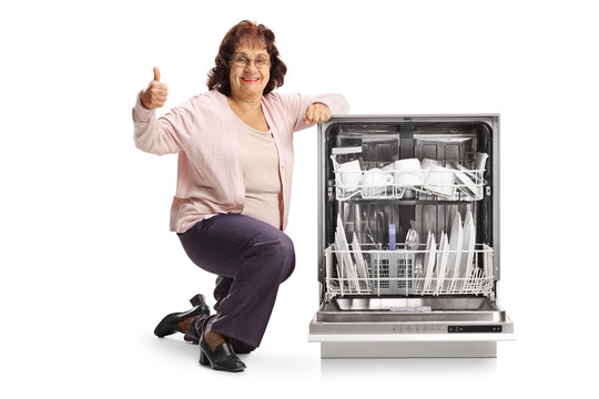 Elderly woman with a dishwasher showing thumbs up