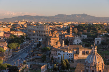 Fototapeta na wymiar Rome, view of the city in the evening, the Forums, the Colosseum and the mountains.