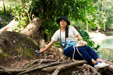 Naklejka na ściany i meble Traveler thai woman travel and posing for take photo at Chet Sao Noi small waterfalls at Muak Lek District in the Saraburi Province of Thailand.