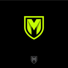 M letter in a shield. M origami monogram consist of green ribbon. Web, UI icon, isolated on a dark background.