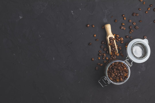 Glass jar with roasted beans and wooden scoop