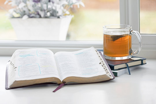 Photograph of a Bible open in front of a window for morning quiet time