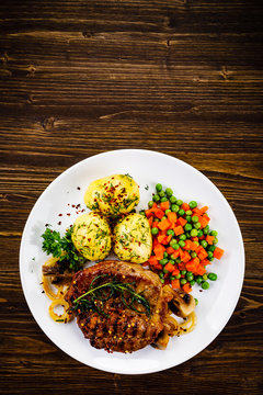 Grilled steak with potatoes and vegetable salad