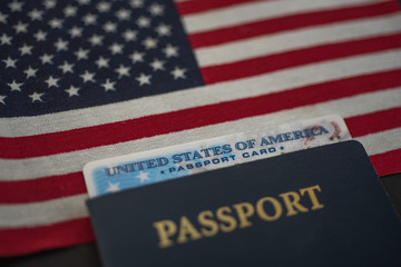 Passport card of USA covered by  International American classic Passport on US Flag. Diagonal view.