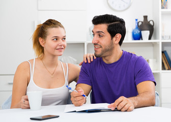Loving couple with papers at home