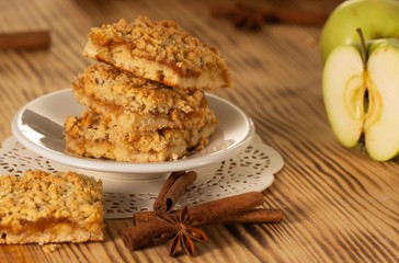 homemade apple pie on a white plate which stands on an old wooden table close-up with a copy space