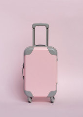 Pink suitcase on a pink background. Minimalism