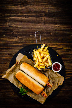 Hot dogs and french fries on black stone plate
