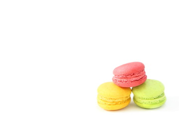 Close up colorful fresh macarons (Reggae color - green, yellow, red) pile isolated on white background, look delicious, have copyspace