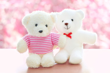 Close up couple of small white bear sitting on wooden table on pink heart bokeh, concept valentine day