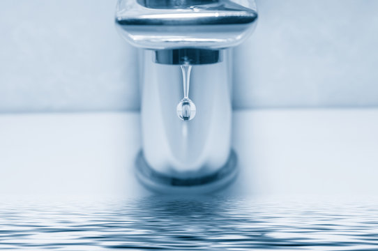 Faucet with water drop close up