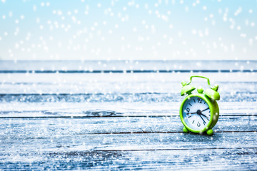 beautiful alarm clock in winter on nature in the park celebrations background