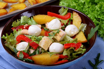 Salad with chicken, roasted potato, mozzarella cheese and red pepper in a bowl