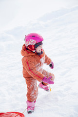 A child rides a sled from a hill.