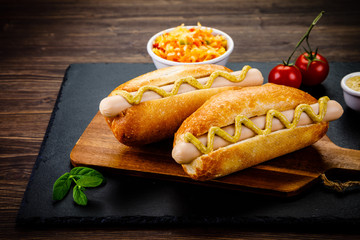 Hot dogs on cutting board on black stone plate