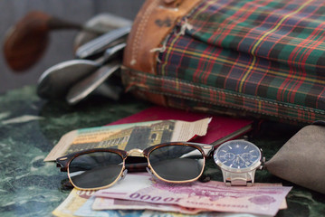 watch, sunglasses, money, golf equipment on a table of marble