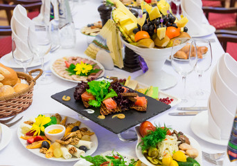 Delicacies, snacks and fruit on the festive table in the restaurant. Celebration. Catering. Banquet table.