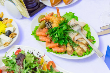 Cold appetizers, seafood and green vegetables at the Banquet table in the restaurant.