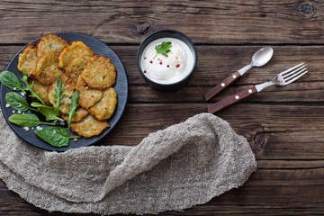 potato pancakes with sour cream on  wooden table