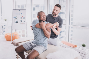 Obraz premium Cheerful dark-skinned man visiting his professional therapist