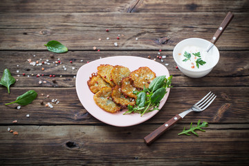 potato pancakes with sour cream on  wooden table
