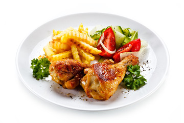 Drumsticks with french fries and vegetable on white background