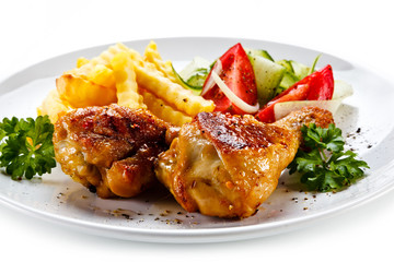Drumsticks with french fries and vegetable on white background