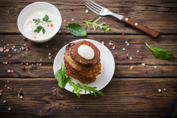 potato pancakes with sour cream on  wooden table