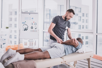 Professional doctor doing rehabilitation exercises with patient - obrazy, fototapety, plakaty